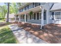 Welcoming front porch with classic white columns and dark shutters, providing a shaded outdoor space at 714 Lanford Springs Sw Dr, Lilburn, GA 30047