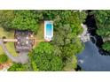 Aerial shot of an estate featuring a pool and lush landscape, nestled near a lake at 8925 Huntcliff Lake Ct, Atlanta, GA 30350