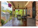 Covered front porch with outdoor seating, decorative lights, and views of the green yard at 107 Estates At The Lake Dr, Canton, GA 30114