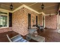 Spacious covered front porch with outdoor seating and brick walls with decor and black shutters at 107 Estates At The Lake Dr, Canton, GA 30114