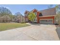 Brick two-story home with a well-manicured lawn and large driveway leading to an attached two car garage at 2433 Idlewood Way, Snellville, GA 30078