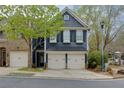 Inviting home exterior featuring a well-manicured lawn, covered entrance, and two-car garage with stylish, dark blue siding at 2700 Ridge Run Tr Trl, Duluth, GA 30097