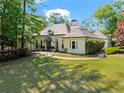 Charming stucco home featuring mature trees, manicured lawn, and covered entryway at 300 Brayward Chase, Roswell, GA 30076