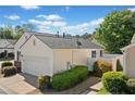 View of home with a white privacy fence, attached garage and neatly trimmed shrubbery at 1228 W Oaks Way, Woodstock, GA 30188