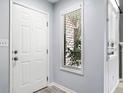 Bright entryway with white door, transom window and light gray walls and gray wood-look floors at 1401 Parkaire Xing, Marietta, GA 30068