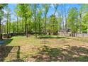 Expansive backyard surrounded by lush trees and a wooden fence at 230 Oakridge Se Dr, Cartersville, GA 30121