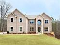 Beautiful two-story brick home featuring a manicured lawn, elegant windows, and a welcoming front entrance at 237 Lotus Ln, Covington, GA 30016