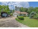 Home with attached garage, extended driveway with carport, mature landscaping and lawn at 1760 Commonwealth Trl, Cumming, GA 30041
