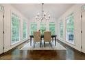 Sun-filled dining room with hardwood floors, modern chandelier, and large windows overlooking the backyard at 1250 Northcliff Trce, Roswell, GA 30076