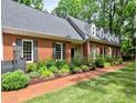 Charming brick home with landscaped front and side yard featuring black shutters and a brick walkway at 1250 Northcliff Trce, Roswell, GA 30076