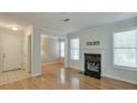 Bright living room with hardwood floors, fireplace with black tile hearth, and a white front door at 2120 River Heights Se Walk, Marietta, GA 30067