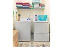 Functional laundry area with washer, dryer, and shelving for organized storage at 4924 Antelope Cv, Atlanta, GA 30349