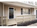 Inviting covered front porch with black door and details, and a wood trimmed railing at 5000 Northland Sw Rd, Mableton, GA 30126