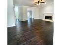 Open living room with dark wood floors, fireplace, and doorway to a sunroom at 180 Shyrewood Dr, Lawrenceville, GA 30043