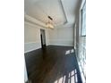 Bright living room featuring dark wood floors, crown molding, and a modern chandelier at 180 Shyrewood Dr, Lawrenceville, GA 30043