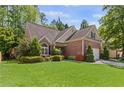 Beautiful brick home featuring a green lawn, enhanced by well-placed landscaping and mature trees in the background at 2106 Berryhill Se Cir, Smyrna, GA 30082