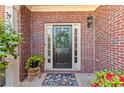 Inviting front door framed by brick, enhanced with a wreath, decorative rug, and potted plants for a warm welcome at 2106 Berryhill Se Cir, Smyrna, GA 30082