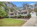 A cozy home featuring an extended driveway and detached garage, all surrounded by dense trees at 469 Kimberly Ct, Mcdonough, GA 30252