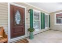 Inviting front porch showcasing a decorative wood door, green shutters, and lovely accents at 469 Kimberly Ct, Mcdonough, GA 30252