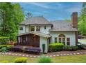 Inviting home back exterior with screened porch, patio, and a well-maintained yard with mature trees at 104 Fairway Overlook, Woodstock, GA 30188
