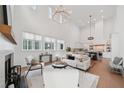 Open-concept living room with high ceilings, modern chandelier, stylish seating, and seamless flow into the kitchen area at 135 Channing Ln, Fayetteville, GA 30214