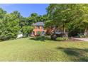 Beautiful brick home with a lush green lawn and mature trees at 3051 Deanna Way, Lawrenceville, GA 30044