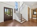 Elegant foyer with hardwood floors, a modern staircase, and a glimpse into a stylish bathroom at 1095 Lanier Pl, Cumming, GA 30041