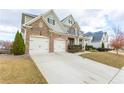 Two-story home with brick and stone accents, showcasing a spacious driveway and well-maintained lawn at 3945 Starwood Dr, Cumming, GA 30028