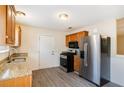 Functional kitchen with stainless steel appliances, granite countertops, wood cabinets, and gray vinyl flooring at 175 Regency Park Dr, Mcdonough, GA 30253