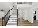 Bright and airy entryway featuring hardwood floors, staircase with black railing, and modern lighting at 4581 Hickory Run Nw Ct, Acworth, GA 30102