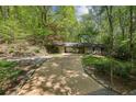 Long driveway leading to home with portico, complemented by lush landscaping and mature trees at 3311 Stillhouse Se Rd, Atlanta, GA 30339