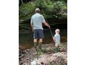 Father and son enjoy the outdoors, fishing in the creek at 3311 Stillhouse Se Rd, Atlanta, GA 30339