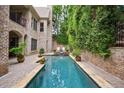 Secluded backyard pool surrounded by lush greenery and a brick privacy wall for a private outdoor oasis at 3250 Twisted Branches Ln, Marietta, GA 30068