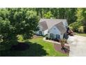 Aerial shot showcases home, landscaped yard, and concrete driveway against a backdrop of lush, mature trees at 7375 Cavaletti Cir, Cumming, GA 30040