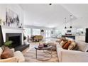Open-concept living room with hardwood floors, brick fireplace, and an abundance of natural light at 7375 Cavaletti Cir, Cumming, GA 30040