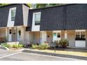 Charming townhome featuring brick facade, well-maintained landscaping, and black shingle roofing at 5180 Chemin De Vie, Atlanta, GA 30342