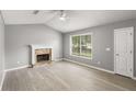 Living room with a stone fireplace, lots of natural light, ceiling fan and neutral paint at 402 Leslie Ct, Mcdonough, GA 30253