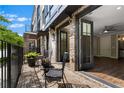 A cozy outdoor patio with brick flooring, wrought iron furniture, and double door access to the home at 1059 Abington Ct, Brookhaven, GA 30319