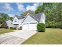 Charming two-story home with a two-car garage, lush lawn, and mature trees at 1444 Bridgewater Br, Stone Mountain, GA 30088