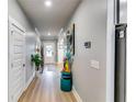 Hallway with light wood floors and neutral walls featuring decorative art at 3260 Summerpoint Xing, Cumming, GA 30028
