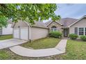 Well-kept house showcasing a two-car garage, stone detailing, and a curved walkway at 4719 Score Ct, Snellville, GA 30039