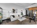 Comfortable living room with sofa, coffee table, and adjacent kitchen at 1805 Harvard Ave # 207, College Park, GA 30337