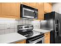 Close-up of the kitchen with stainless steel appliances and wood cabinets at 2103 Stratford Commons, Decatur, GA 30033