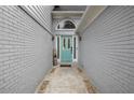 Inviting entryway with a stylish turquoise door, gray painted brick and modern lighting fixtures at 3568 Foxworth Ct, Buford, GA 30519