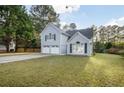 Beautiful home exterior featuring a landscaped lawn, attached garage, and light blue painted brick at 3568 Foxworth Ct, Buford, GA 30519