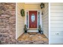 Home's front door featuring a decorative wreath and stone facade at 7420 Colony Ct, Cumming, GA 30041