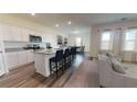 Modern kitchen boasts white cabinetry, granite countertops, stainless steel appliances, and bar seating at 7770 Sudbury Cir, Covington, GA 30014