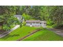 An aerial view of a single-story home on a green lawn, with surrounding trees and neighboring houses nearby at 2037 Lenox Ne Rd, Atlanta, GA 30324