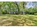 Charming one-story home with black shutters surrounded by mature trees and a spacious front lawn at 2963 Williams Pl, Snellville, GA 30078