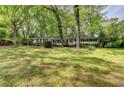 Charming one-story home with black shutters surrounded by mature trees and a spacious front lawn at 2963 Williams Pl, Snellville, GA 30078